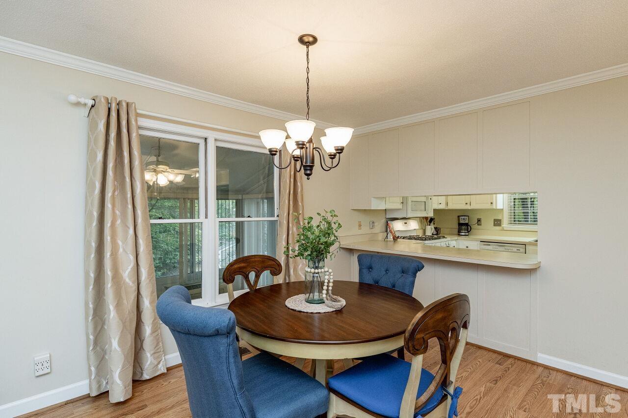7811 Breckon Way Raleigh, NC 27615 - Photo 9 of 30 a dining room with furniture a chandelier and wooden floor