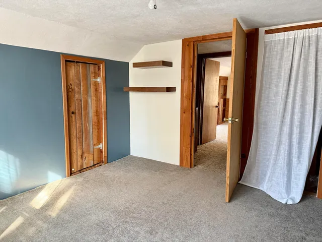 an empty room with closet and a bathroom