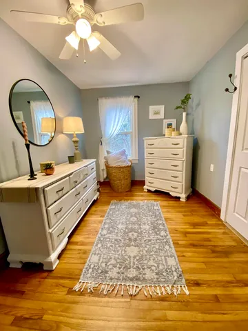 a bed room with a bed and mirror on the dresser