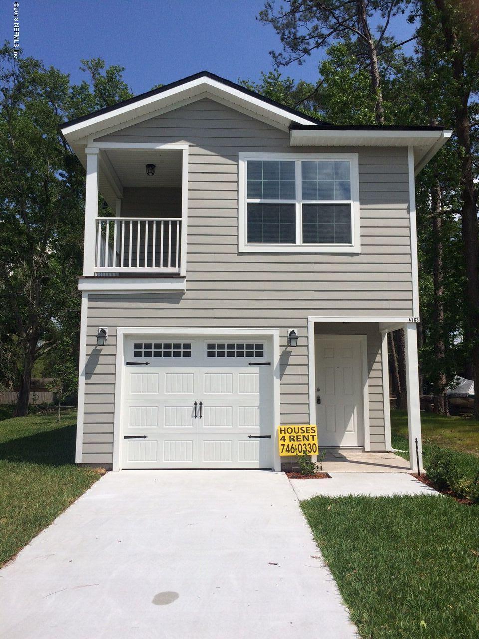 4163 Springwood Road Jacksonville, FL 32207 - Photo 1 of 1 a front view of a house with a garden and trees