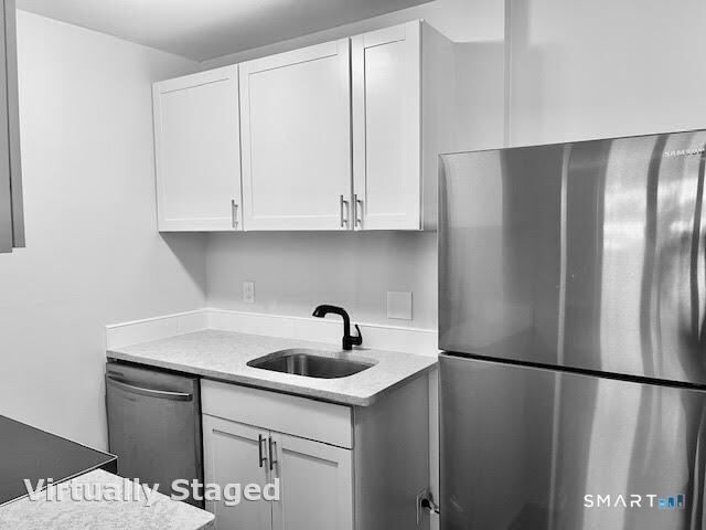 45 Monroe Street, Unit B8 Bridgeport, CT 06605 - Photo 11 of 14 a kitchen with a sink a refrigerator and cabinets