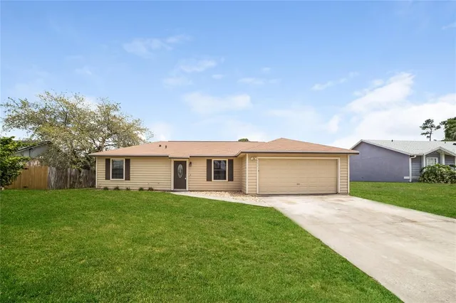 a view of a house with a yard and large tree