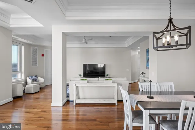a view of a dining room with furniture a chandelier and wooden floor
