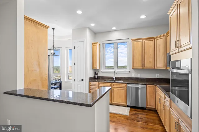 a kitchen with granite countertop a sink a stove and cabinets