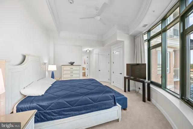 a bedroom with a bed a large window and flat screen tv