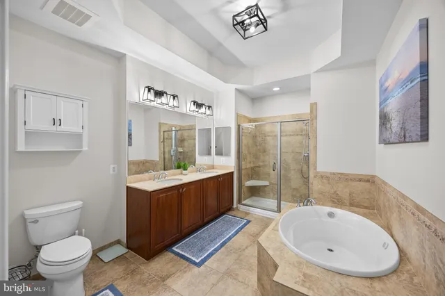 a bedroom with a bed and flat tv screen on the dresser