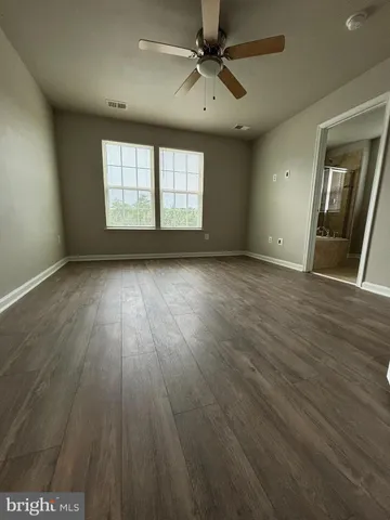 a view of an empty room and a ceiling fan