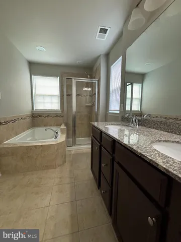 a bathroom with a granite countertop sink a toilet and shower