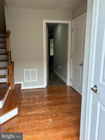 an empty room with wooden floor and a ceiling fan