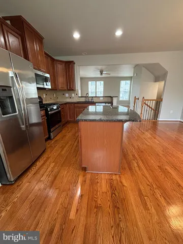 a kitchen with granite countertop a stove and a wooden floors