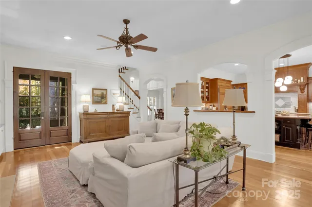 a view of a dining room and livingroom with furniture wooden floor a chandelier