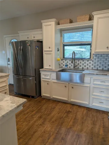 a kitchen with granite countertop a refrigerator and a sink
