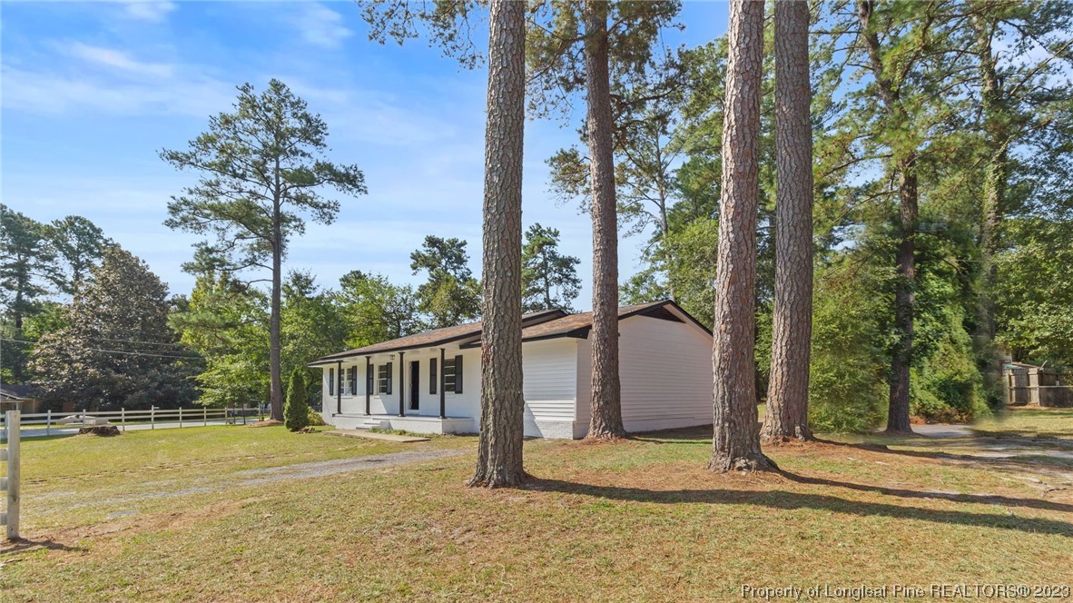 a view of a house with backyard and trees