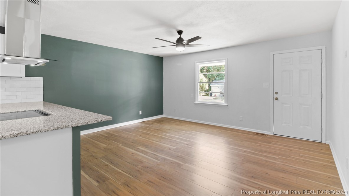 5867 Columbine Road Fayetteville, NC 28306 - Photo 6 of 26 a view of a kitchen that shows a sink hardwood floor and a chandelier fan