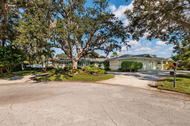 an aerial view of residential houses with outdoor space and trees