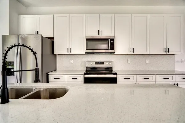 a kitchen with stainless steel appliances granite countertop a sink and a microwave