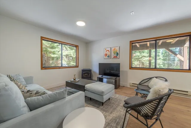 a living room with furniture a flat screen tv and a large window