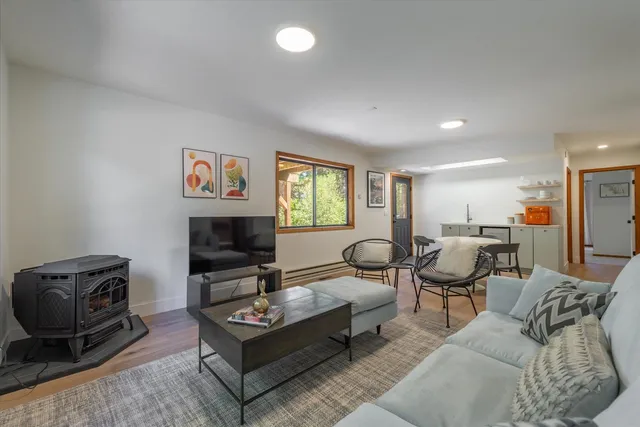 a living room with furniture a flat screen tv and kitchen view