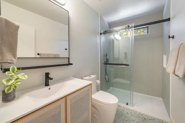 a bathroom with a sink a toilet and shower