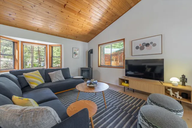 a living room with furniture a flat screen tv and a large window