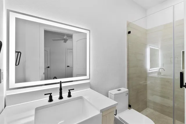 a bathroom with a sink a toilet and shower