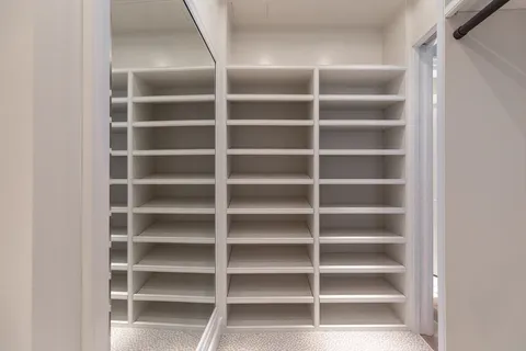 a view of walk in closet with empty racks