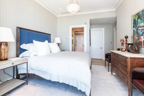 a bedroom with a bed and a chandelier