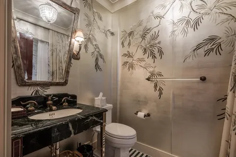 a bathroom with a toilet sink and mirror