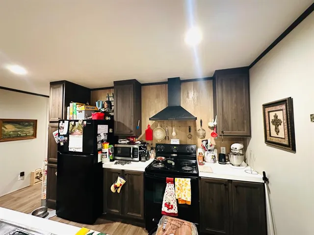 a kitchen with stainless steel appliances granite countertop a stove refrigerator and a sink with wooden cabinets