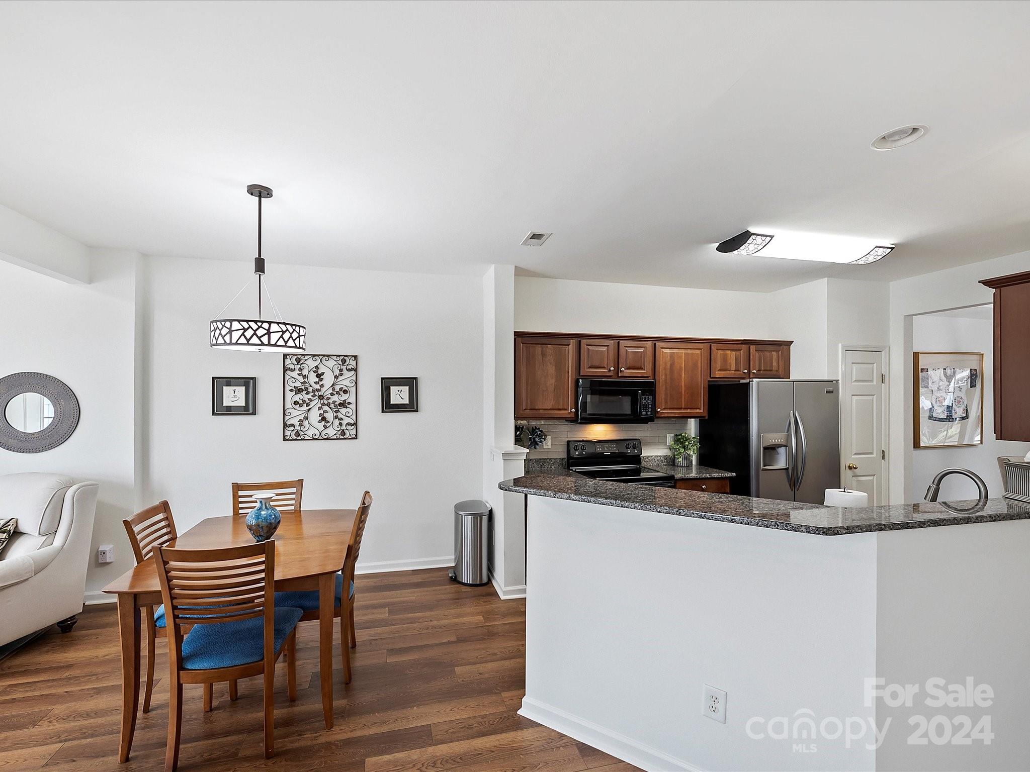 117 Snead Road Fort Mill, SC 29715 - Photo 13 of 36 a kitchen with stainless steel appliances a dining table chairs and a microwave