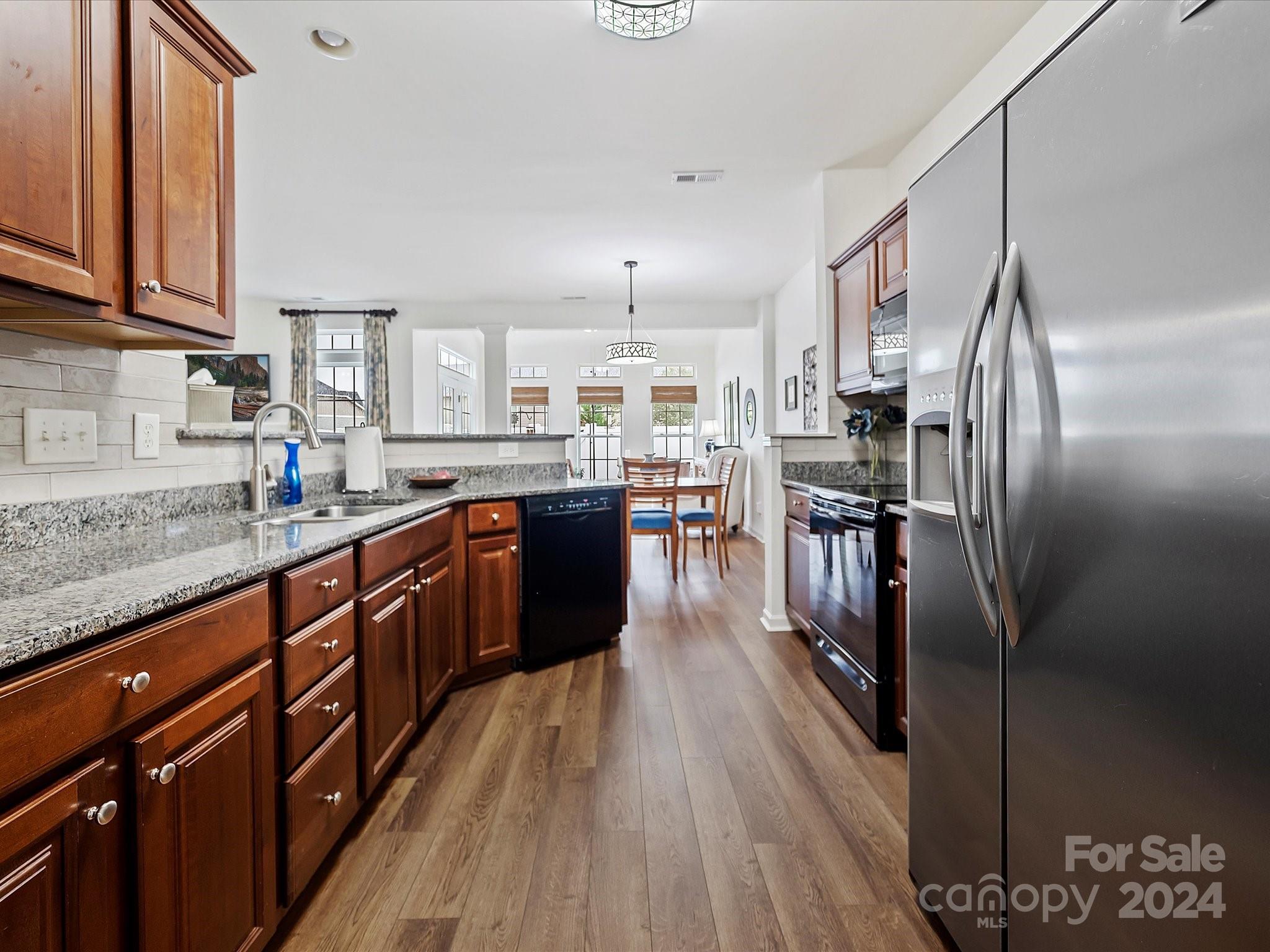 117 Snead Road Fort Mill, SC 29715 - Photo 8 of 36 a kitchen with stainless steel appliances granite countertop a refrigerator a sink dishwasher a stove and white countertops with wooden floor