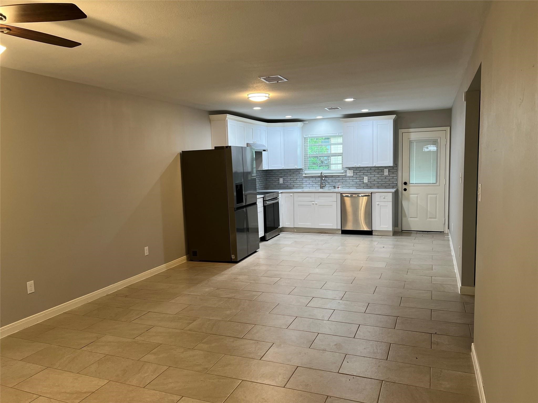 4114 Brown Street Bacliff, TX 77518 - Photo 3 of 12 a large kitchen with a large counter top a refrigerator and cabinets