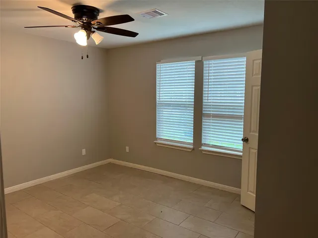 an empty room with a window and a fan