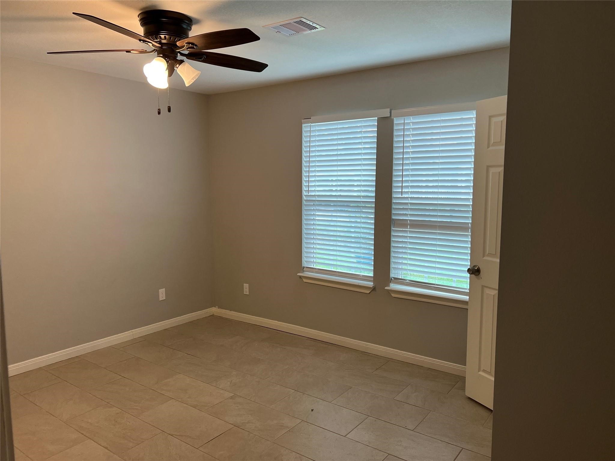 4114 Brown Street Bacliff, TX 77518 - Photo 7 of 12 an empty room with a window and a fan