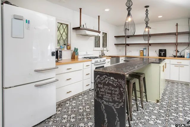 a kitchen with kitchen island a stove a sink and a refrigerator