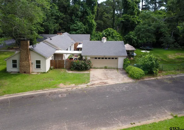 a aerial view of a house with yard and green space