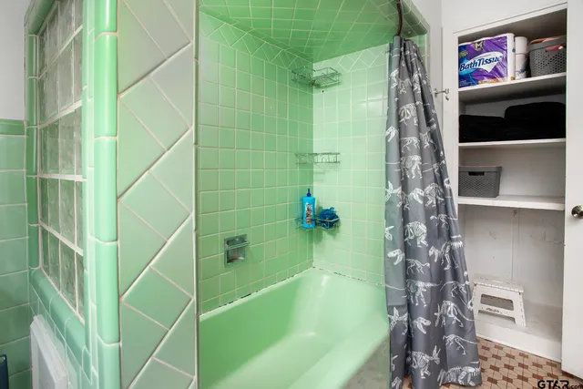 a bathroom with a shower and a bath tub