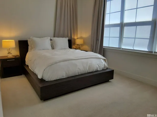 a bed sitting in a bedroom next to a window