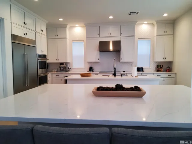 a kitchen with kitchen island a sink stainless steel appliances and cabinets