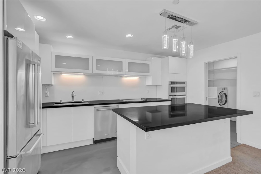 640 North Racetrack Road Henderson, NV 89015 - Photo 48 of 65 A contemporary kitchen features sleek black countertops and stainless steel appliances.