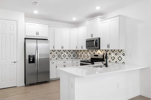 a kitchen with stainless steel appliances a refrigerator sink and microwave