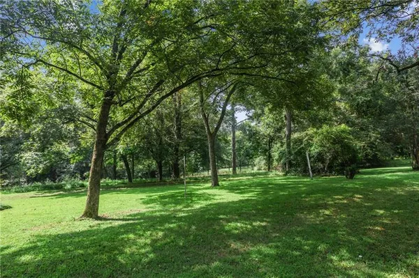 a view of a park with trees in the background