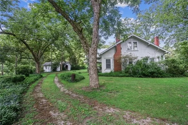a view of a house with yard and tree s