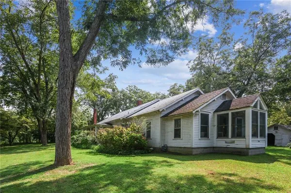 a view of a house with a yard balcony and a tree