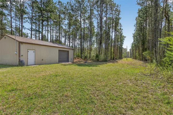 a view of a house with backyard and trees