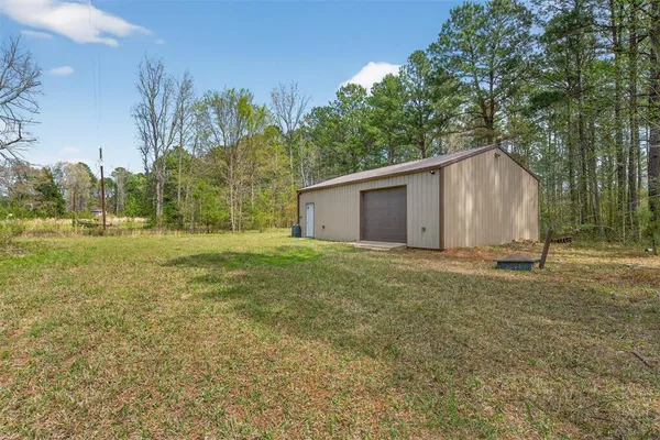 a view of a house with backyard and trees