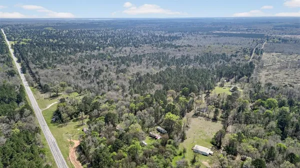 an aerial view of house with yard and mountain view in back