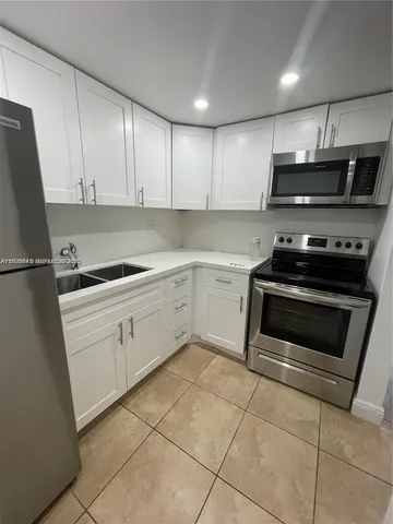 a kitchen with a stove a refrigerator and a sink