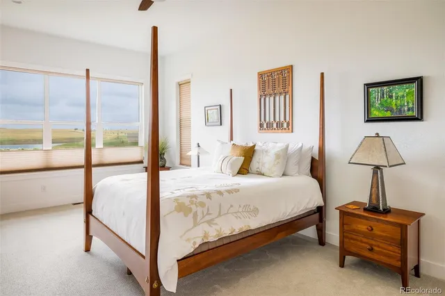 a bedroom with a bed and a lamp next to a window
