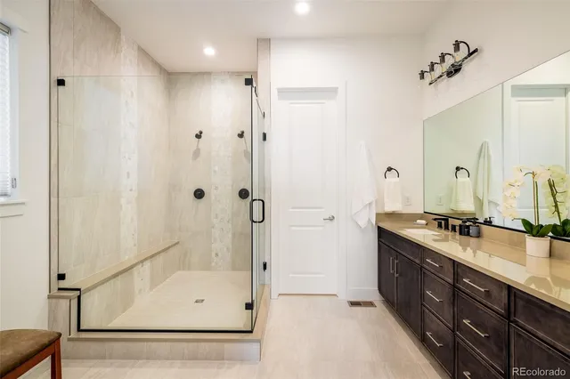 a bathroom with a double vanity sink a mirror and a bathtub